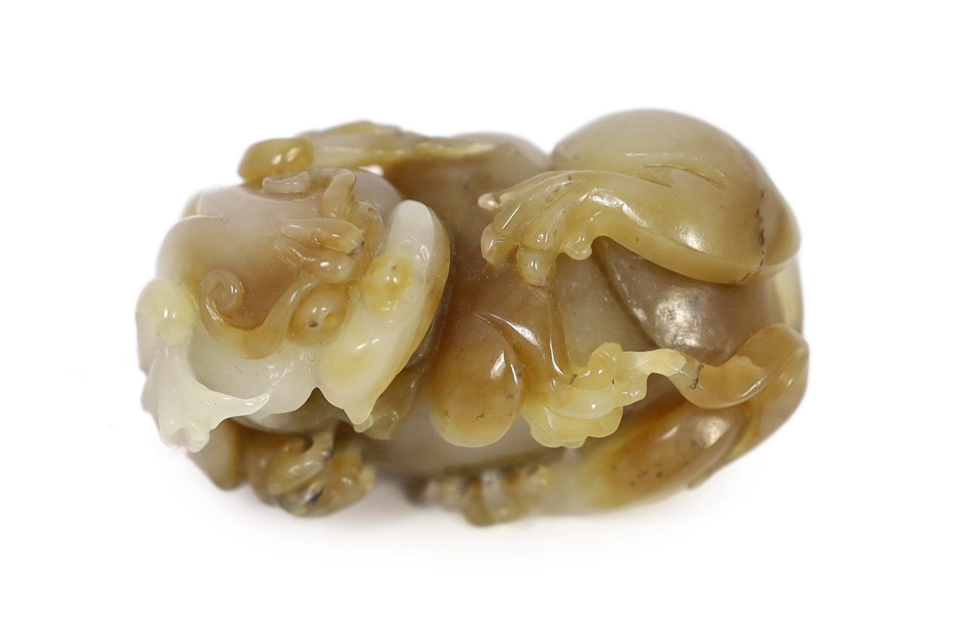 A Chinese white and brown jade lion-dog carving